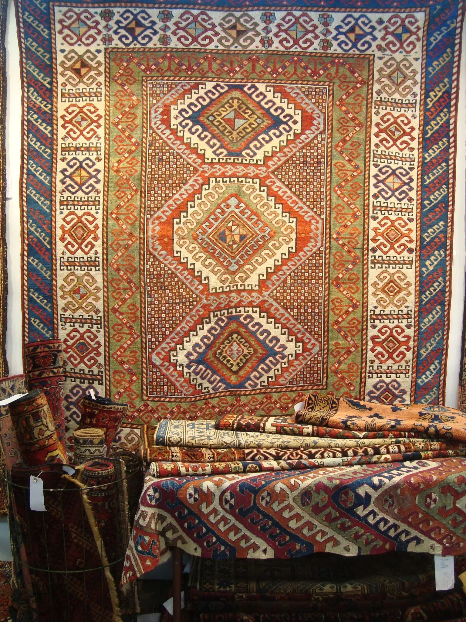 Antique Caucasian Kazak rug featuring bold geometric patterns in red and blue